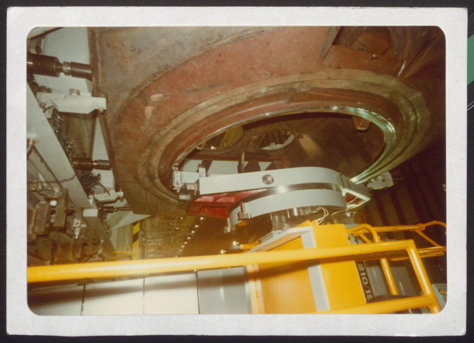Bottom of turret ring being milled, view of bustle dividers through turret ring