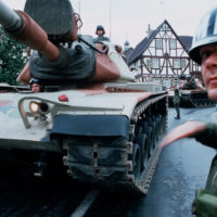 a-us-army-military-policeman-directs-m60-main-battle-tanks-through-a-german-d69802