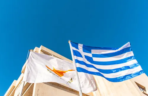 cypriot-and-greek-flags-flying-against-blue-sky